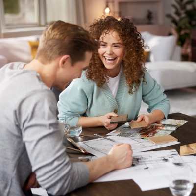 Ein Pärchen sitzt am Esstisch bei Möbel Weber und plant voller Vorfreude die Einrichtung ihrer Traumwohnung mit stilvollen Interliving Möbeln.